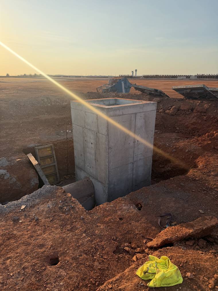 Long run of in-situ concrete drainage structures and ground beams across airfield works.