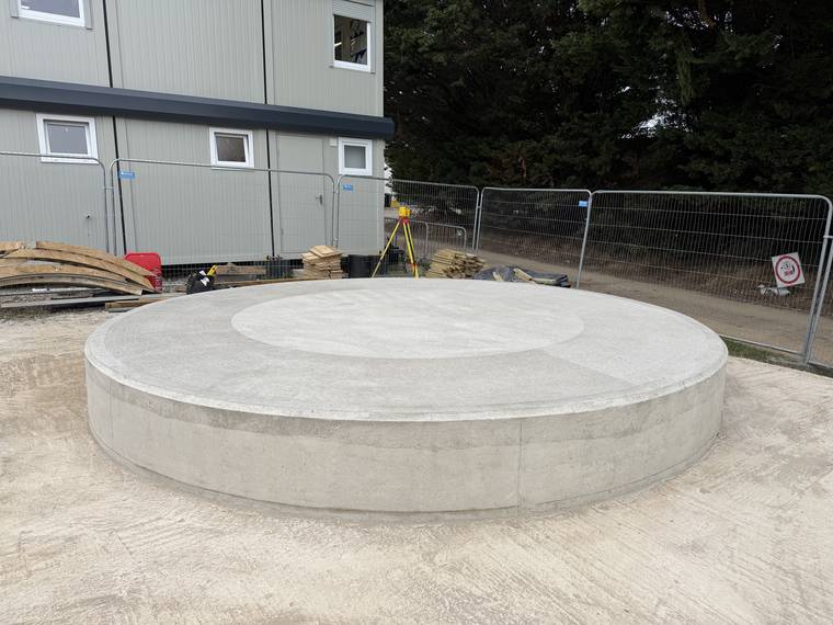 Completed circular concrete plinth with a clean, uniform as-struck finish.